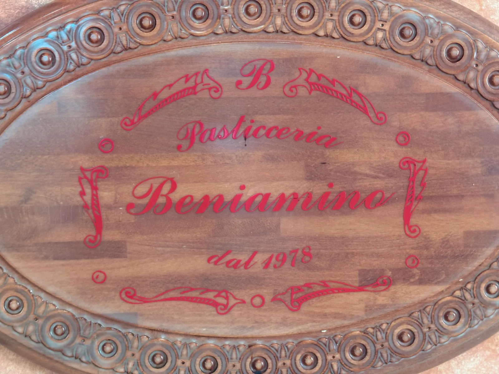 Insegna storica in legno intagliato della Pasticceria Beniamino